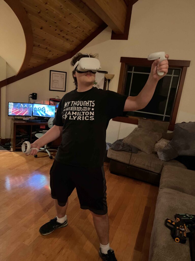 A man in a black shirt holding a virtual reality device.